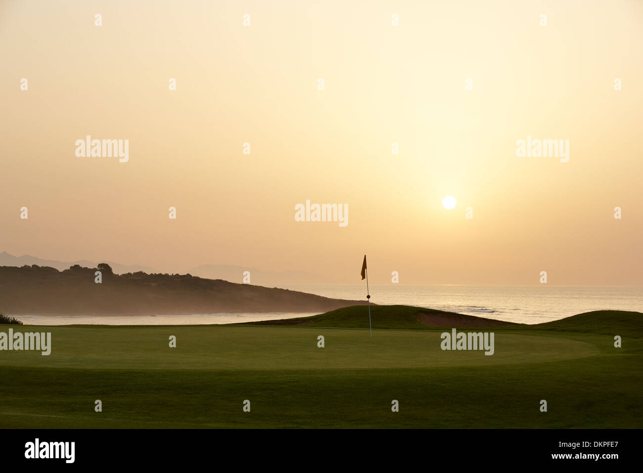 Sonnenuntergang über Meer und Golfplatz Stockfoto