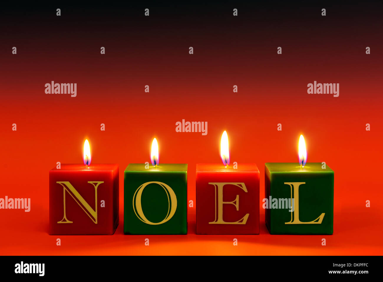 Kerzen, die das Wort NOEL brennende rote abgestuften Hintergrund zu buchstabieren. Stockfoto