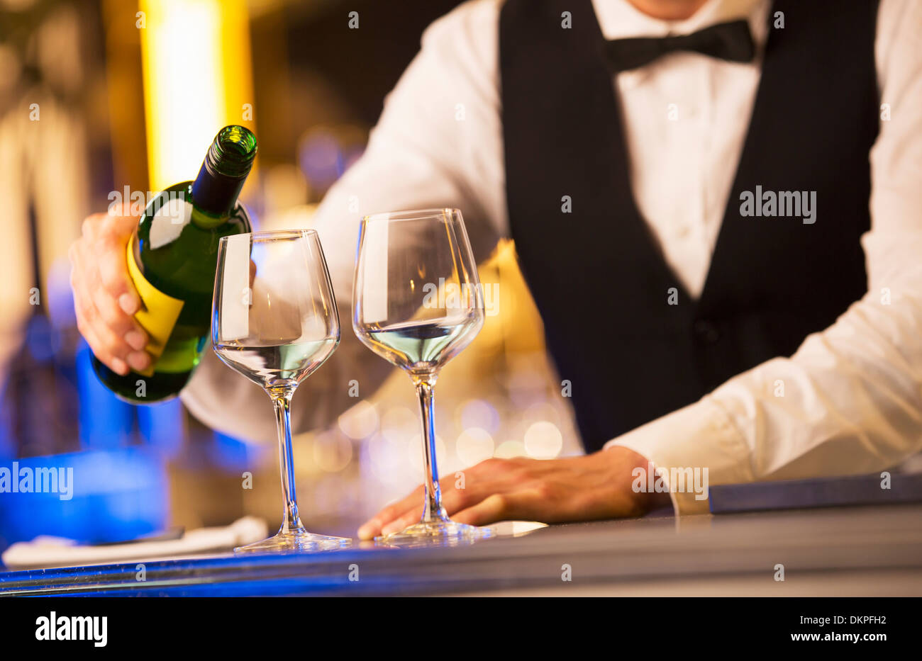 Gut gekleidete Barkeeper gießt Wein Stockfoto