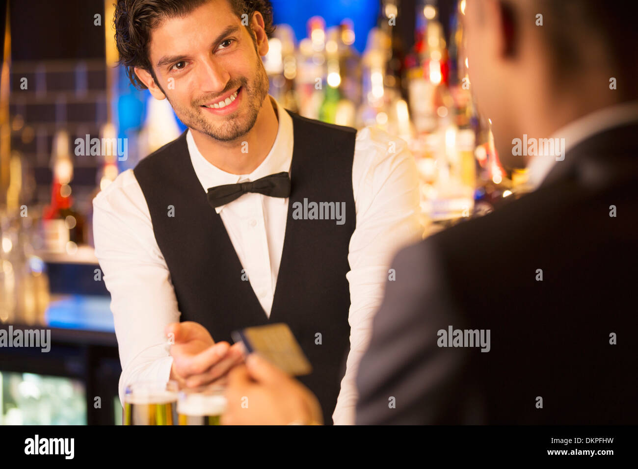 Gut gekleidete Barkeeper die Kreditkarte von Kunden in Luxus bar Stockfoto