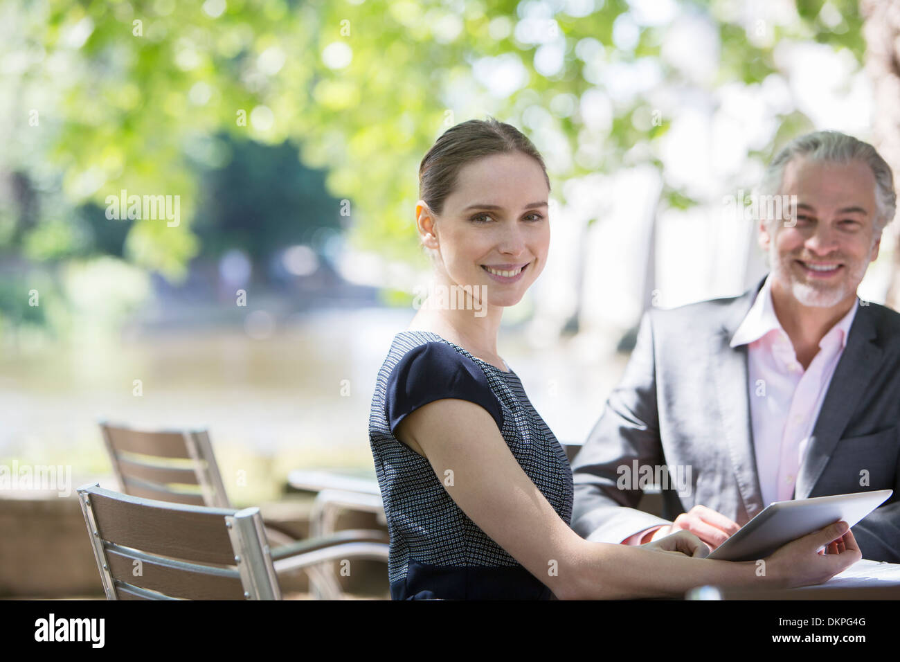 Geschäftsleute, die lächelnd im Straßencafé Stockfoto