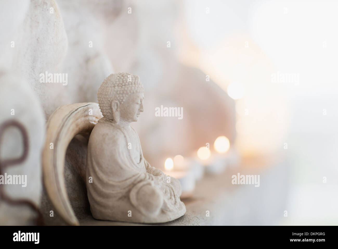 Buddha Figur und Kerzen auf Sims Stockfoto