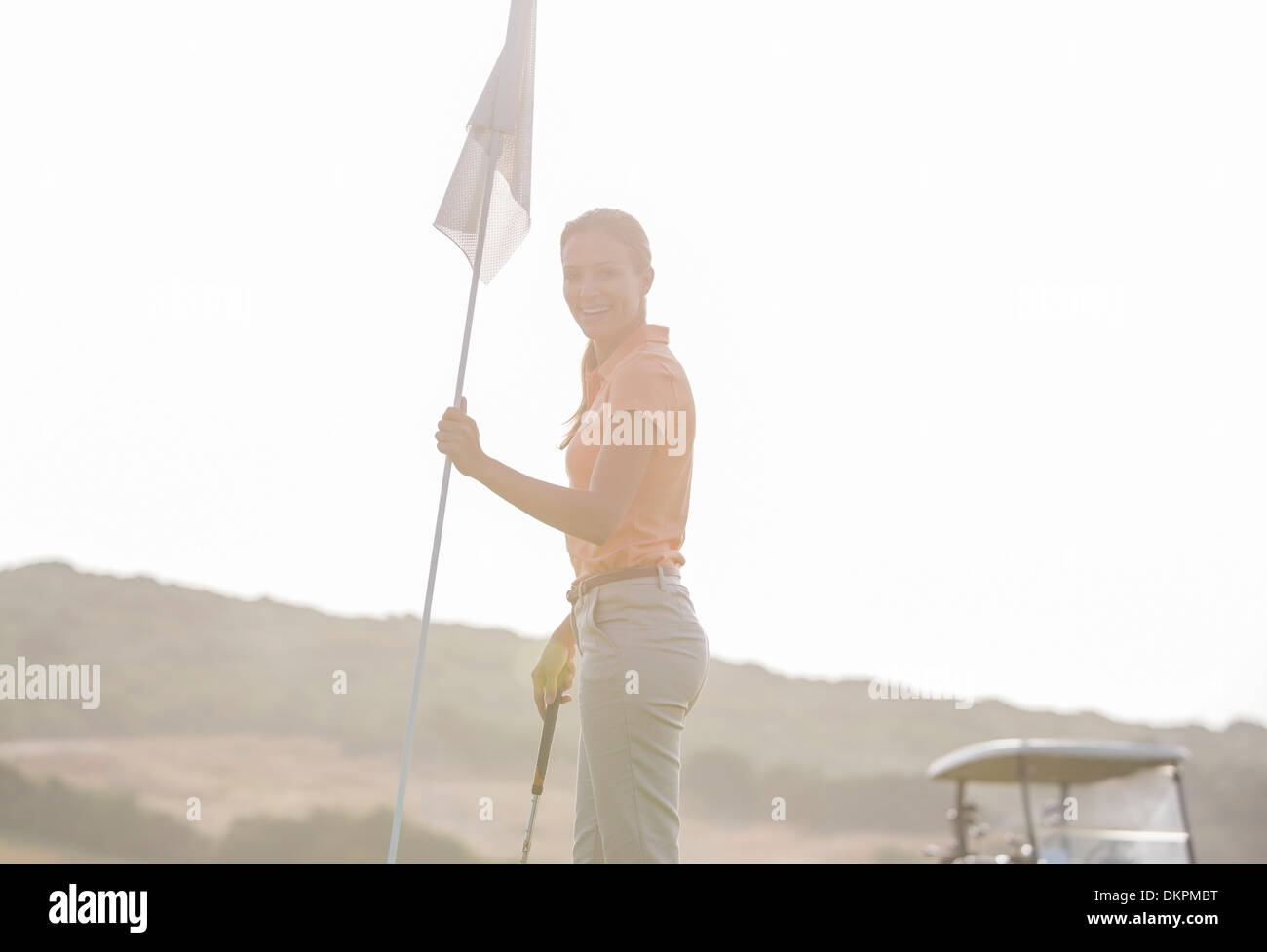 Frau halten Golfflagge Stockfoto