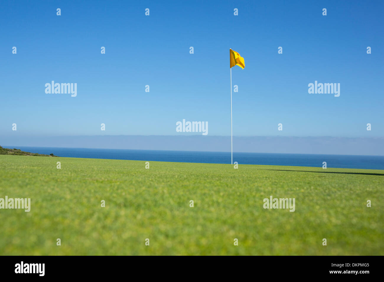 Flagge auf Golfplatz mit Blick auf den Ozean Stockfoto
