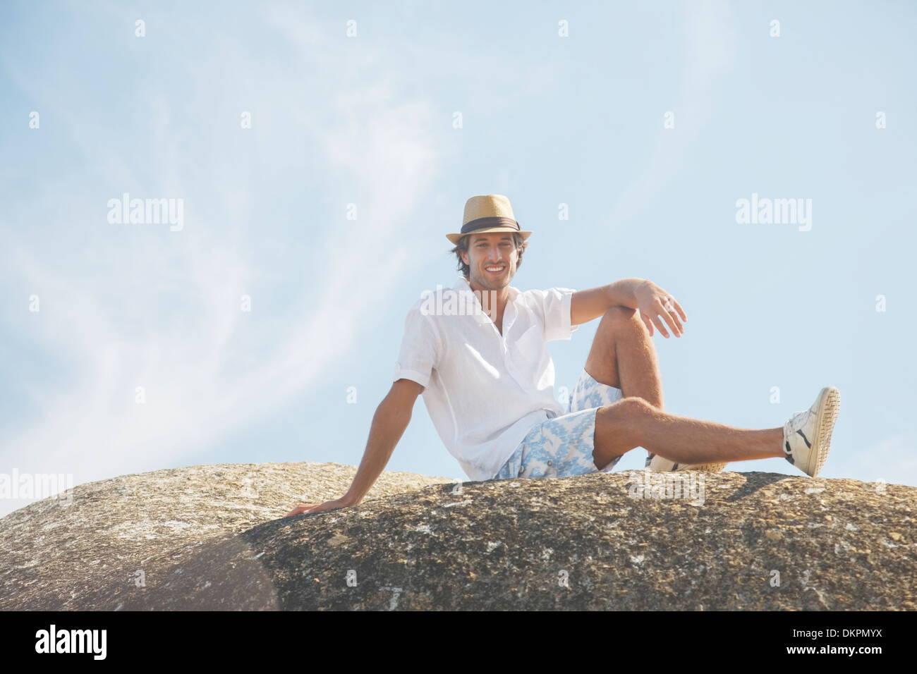 Mann sitzt auf Felsformation Stockfoto