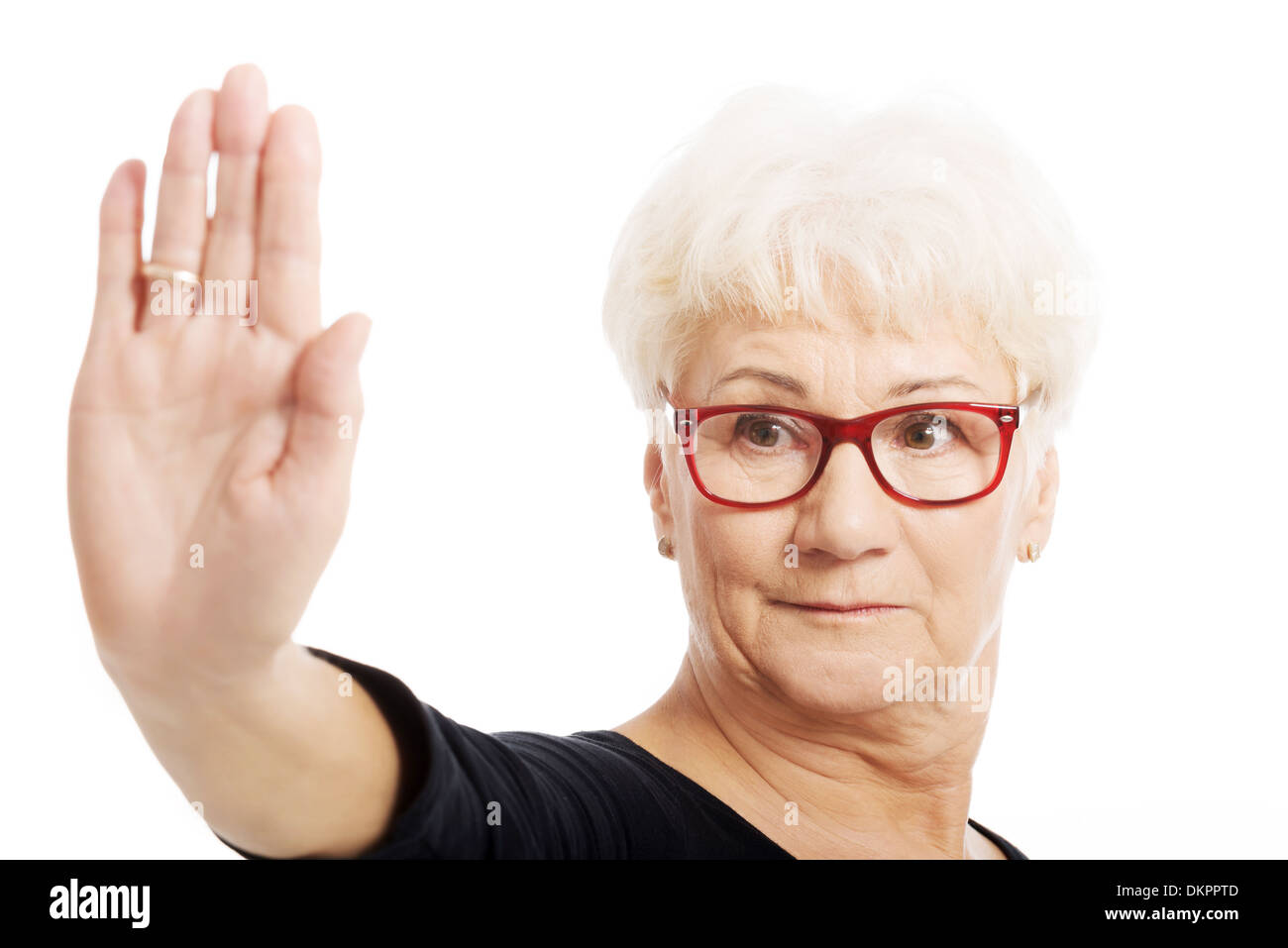 Eine alte Dame zeigt Stoppschild von hand. Isoliert auf weiss. Stockfoto
