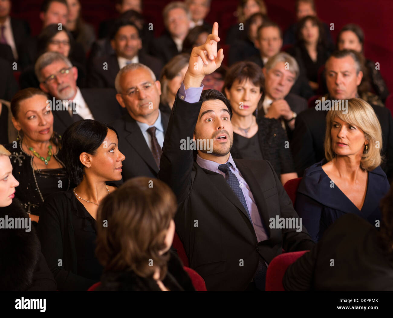 Mann, die Hand im Theater Publikum heben Stockfoto