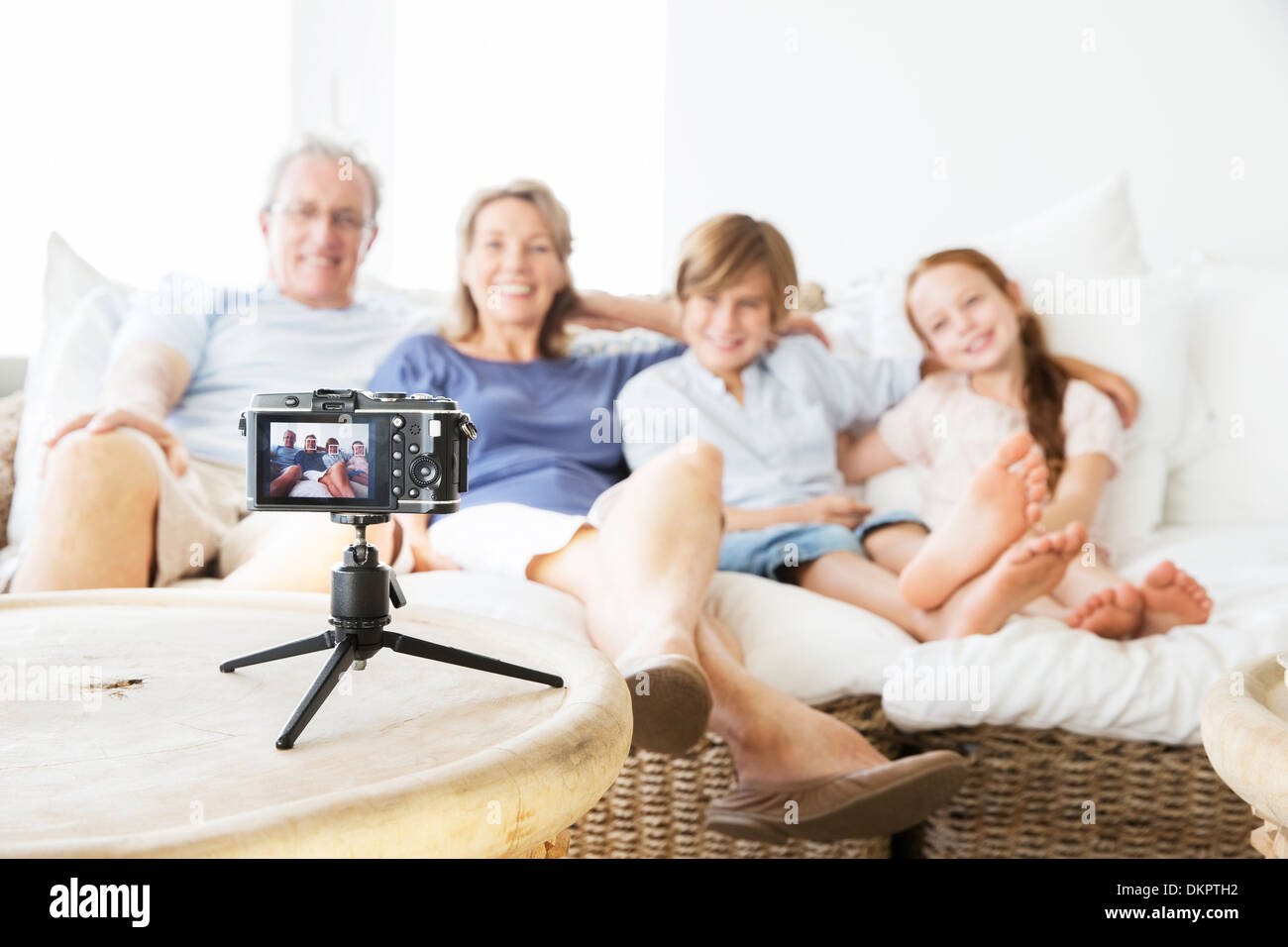 Familie unter Bild von sich selbst auf sofa Stockfoto