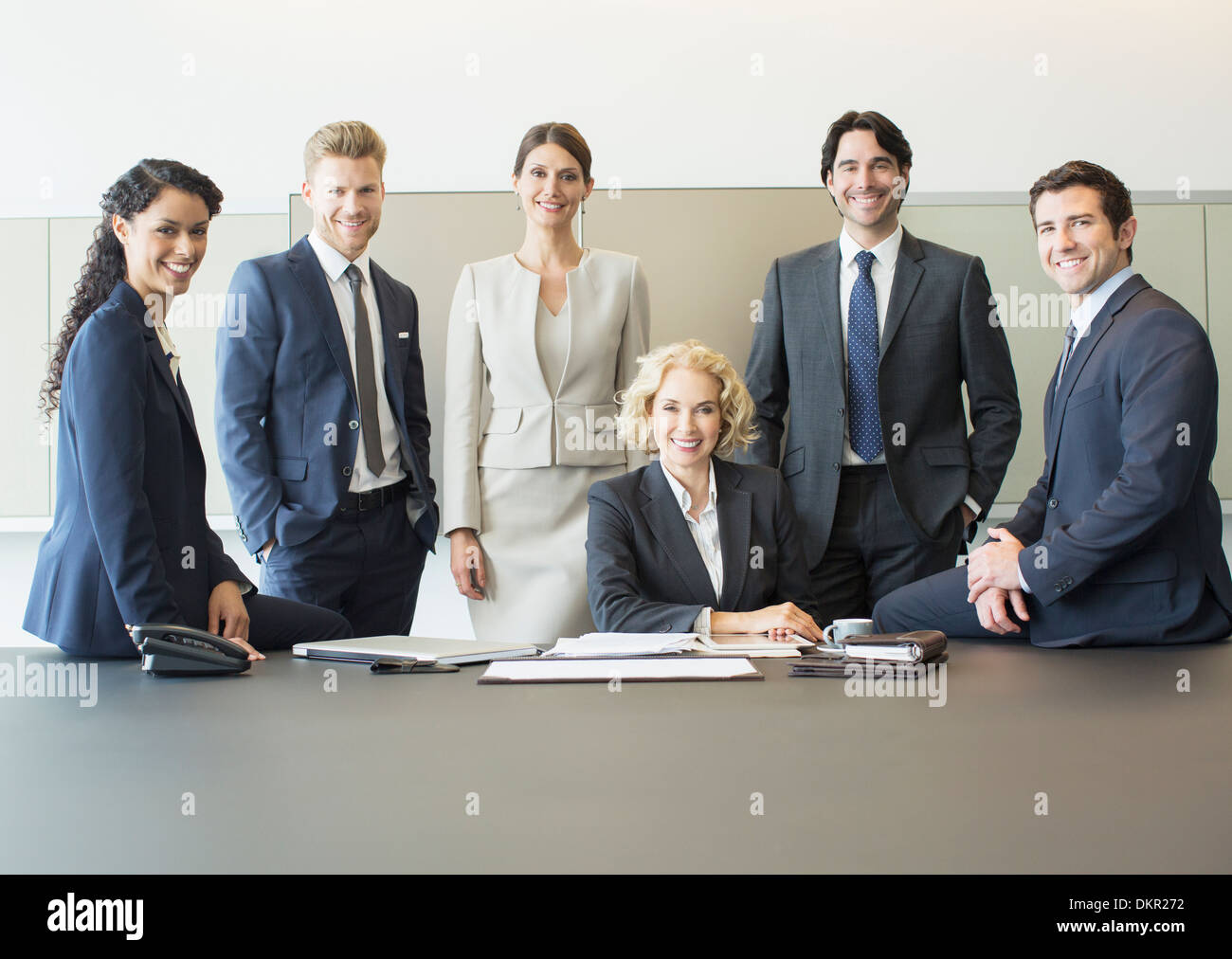 Geschäftsleute, die lächelnd im Konferenzraum Stockfoto