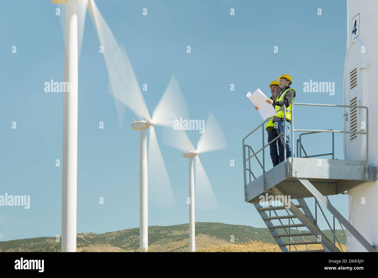 Arbeitnehmer auf Windkraftanlage in ländlichen Landschaft stehend Stockfoto