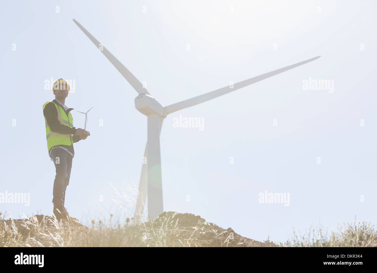 Arbeitnehmer, die durch Windkraftanlagen in der Landschaft im ländlichen Raum stehen Stockfoto
