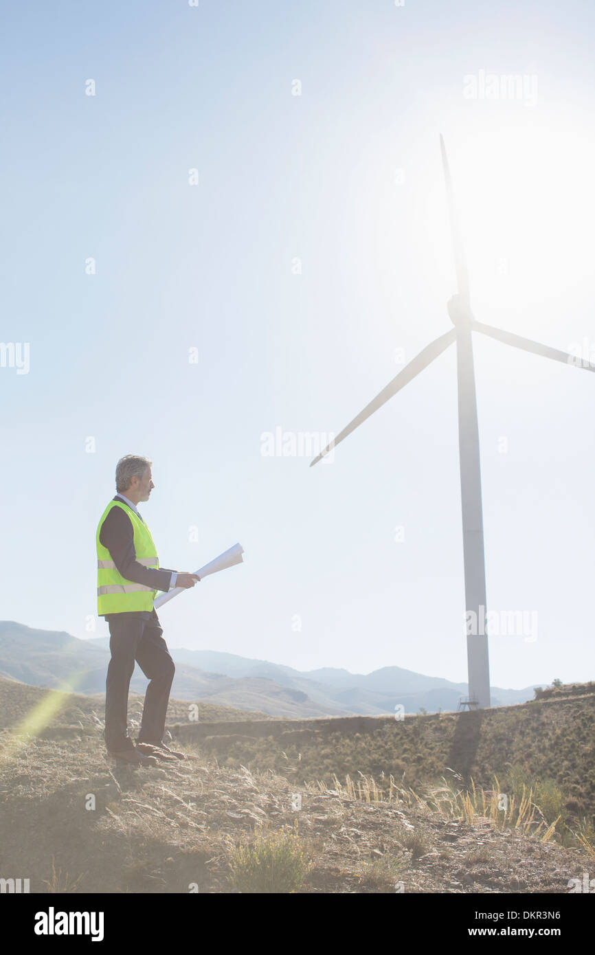 Geschäftsmann, Prüfung der Windturbine in ländlichen Landschaft Stockfoto