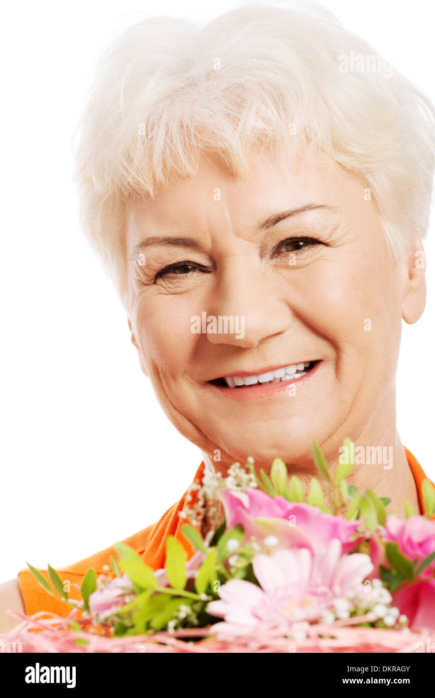 Eine alte Frau mit Blumenstrauß. Isoliert auf weiss. Stockfoto