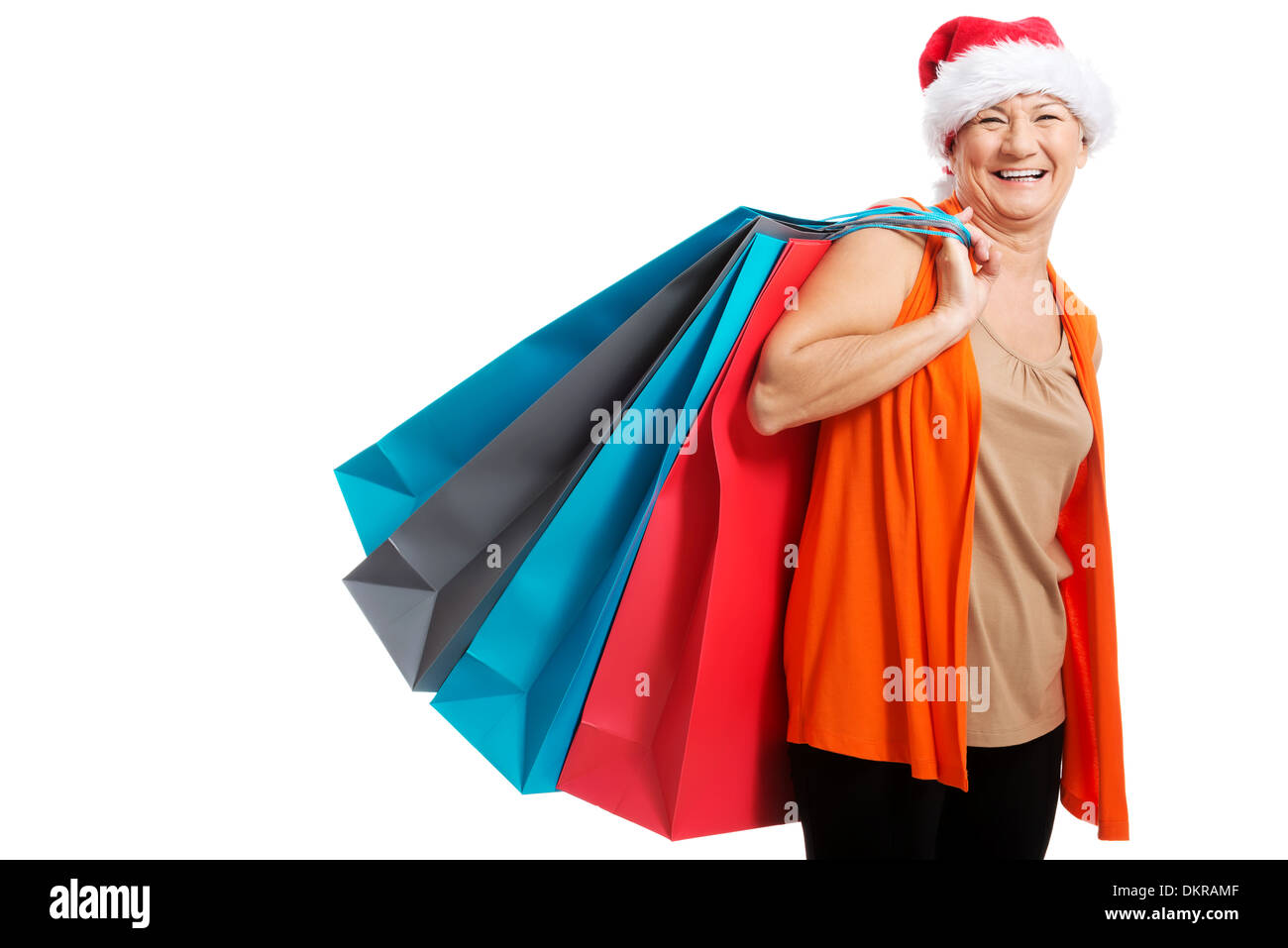 Eine alte Frau Geschenke/Taschen in Weihnachtsmütze hält. Isoliert auf weiss. Stockfoto