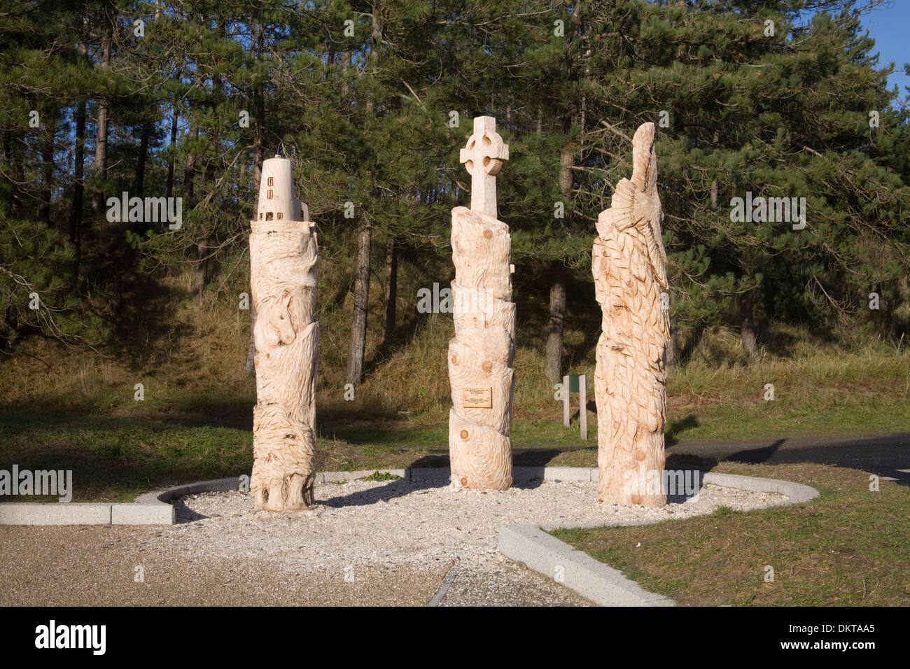 Newborough Wald Anglesey North Wales Holzskulpturen entworfen von lokalen Schulkindern mit Denkmälern von Llanddwyn Island Stockfoto