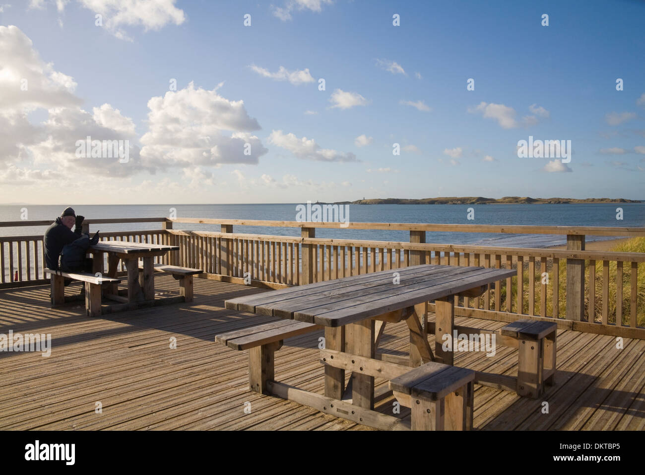 Newborough Anglesey North Wales UK ältere männliche Walker sitzen an neu Picknick-Tische auf Behinderte benutzerfreundliche Plattform gebaut Stockfoto