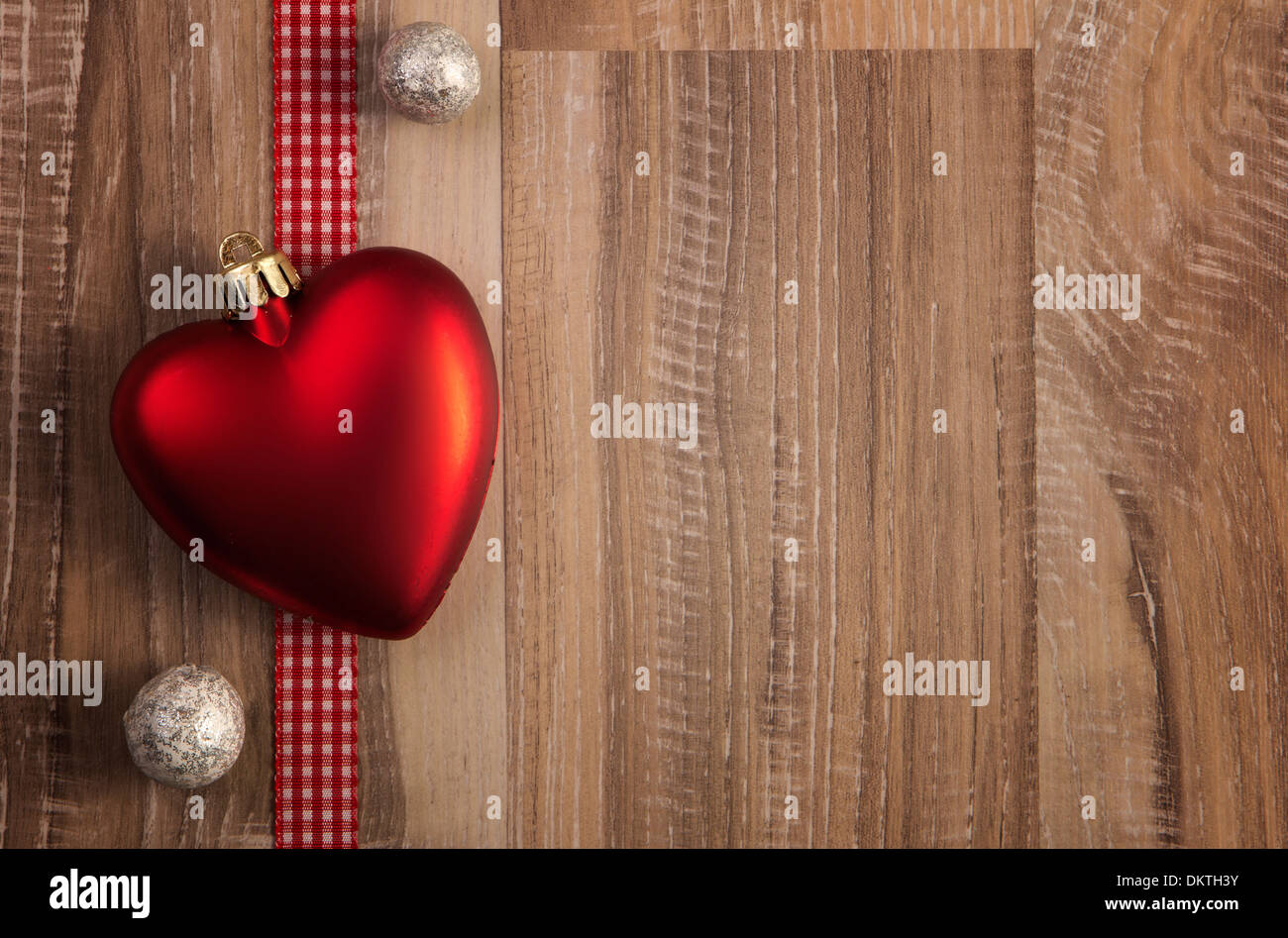 Herz als Weihnachtskugel mit hölzernen Hintergrund Stockfoto