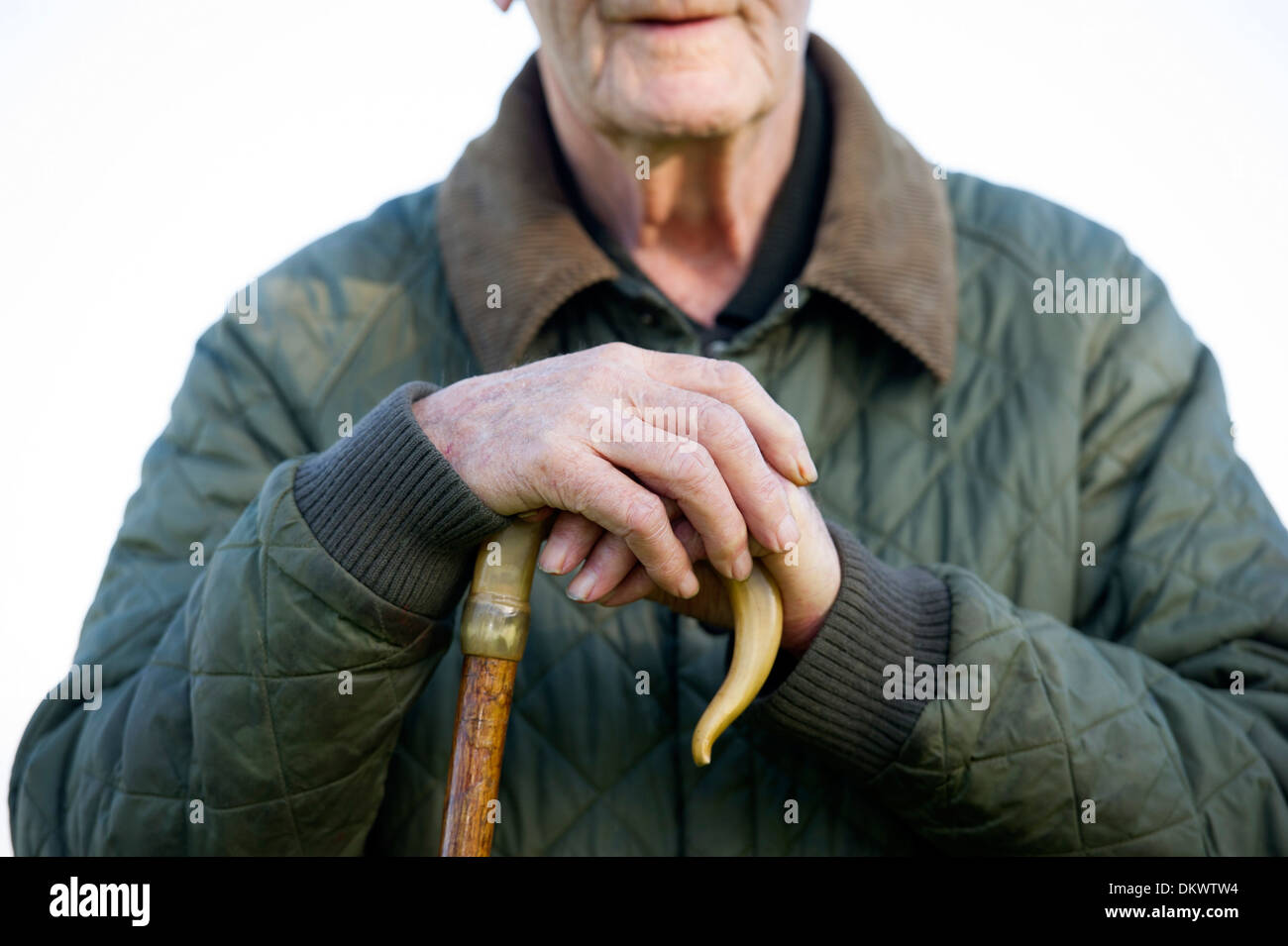 Ein Landwirt ruht seine Hände auf einen Spazierstock beim Schafe hüten. Stockfoto