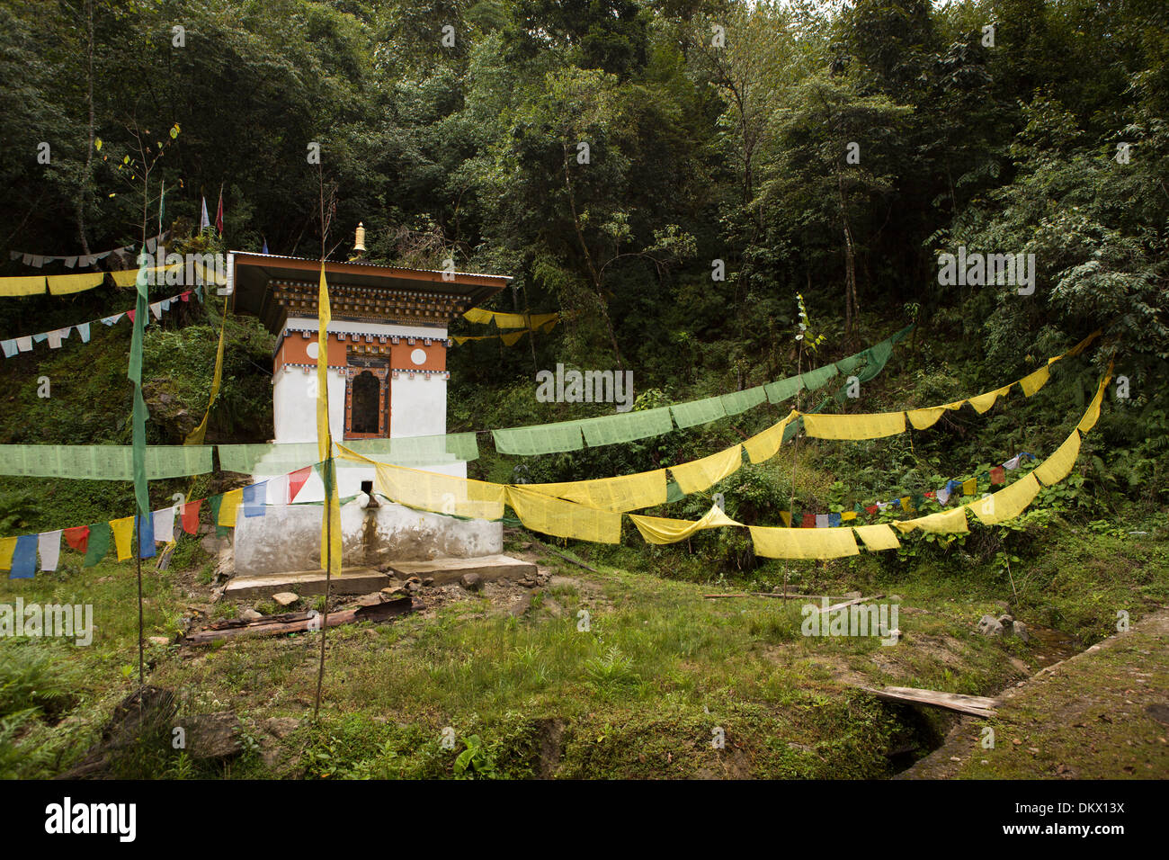 Bhutan, Trongsa, am Straßenrand wasserbetriebene Gebetsmühle mit Gebetsfahnen auf Yotang La Road Stockfoto