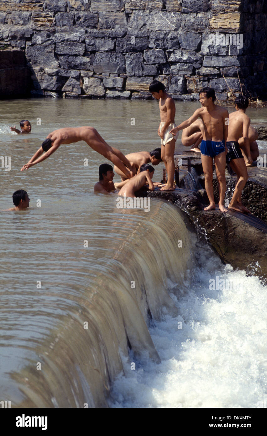 Knaben und Jugendliche, die Spaß in einem Fluss in der antiken Stadt Feng Huang in der chinesischen Provinz Hunan Stockfoto