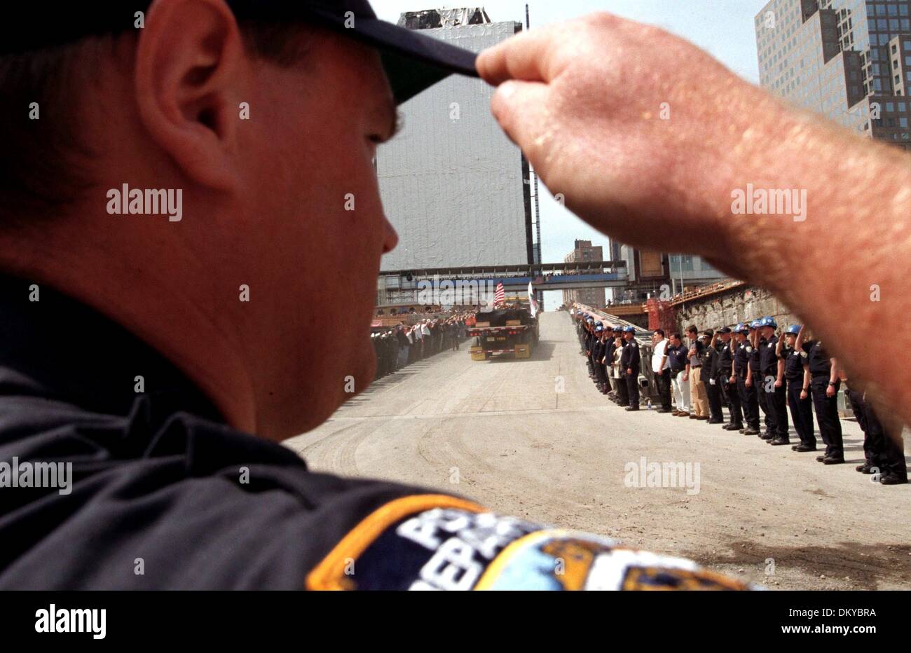 30. Mai 2002 - New York, NY, Vereinigte Staaten von Amerika - Polizist gibt einen Fairwell Gruß als der LKW mit der letzten Trümmer von der World Trade Center Site Kopf nach unten die Denkmal-Prozession. Mit dem Läuten einer Glocke Feuerwache, markieren Sie eine leere Bahre tragen eine amerikanische Flagge und dem Klang der Dudelsäcke, New Yorker das Ende des World Trade Center-Bergung und einen neuen geplanten Stockfoto