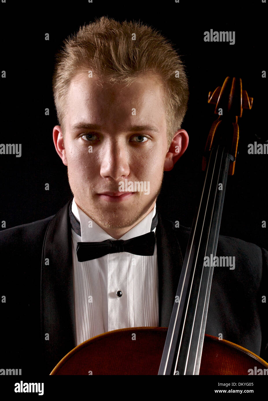 junge kaukasischen Cellisten mit schwarzem Hintergrund Stockfoto