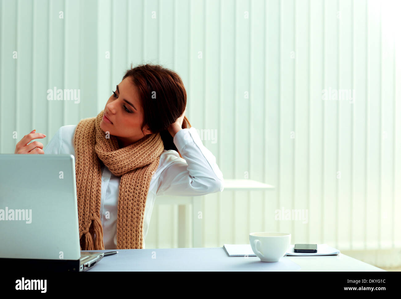 Junge nachdenklich Geschäftsfrau auf ihrem Arbeitsplatz sitzen und wegschauen im Büro Stockfoto