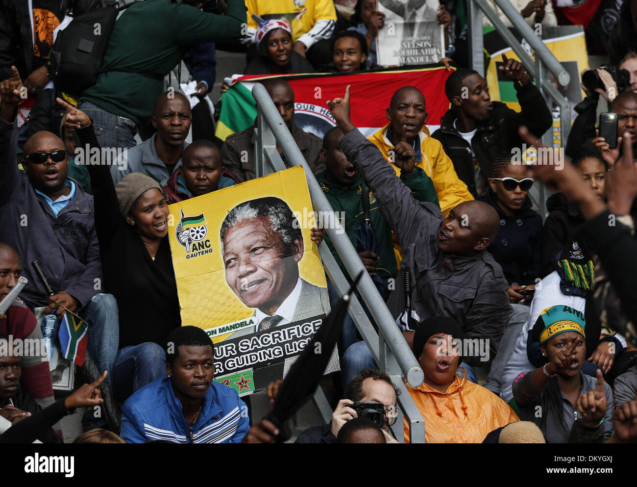 Johannesburg, Südafrika. 10. Dezember 2013. Personen ein Plakat von Nelson Mandela vor der Trauerfeier für den ehemaligen südafrikanischen Präsidenten an das FNB-Stadion in Soweto nahe Johannesburg, Südafrika, 10. Dezember 2013. Bildnachweis: Zhang Chen/Xinhua/Alamy Live-Nachrichten Stockfoto