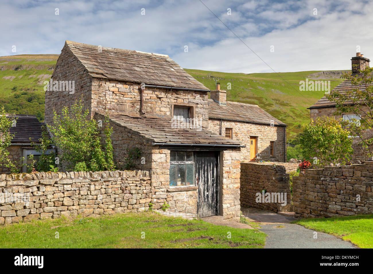 Stein-Bauernhaus mit Scheune in den Yorkshire Dales Dorf Muker, Swaledale, England. Stockfoto