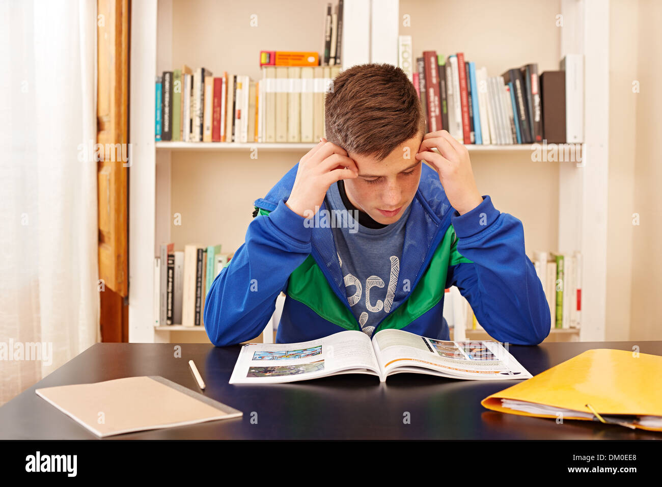 Männlichen Teenager konzentriert studieren in einem Schreibtisch Stockfoto
