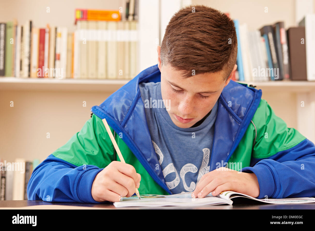 Männlichen Teenager konzentriert Hausaufgaben in einem Schreibtisch Stockfoto