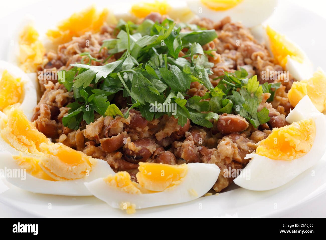 Ägyptische Foul- oder Ful - Medames auf eine Platte Garneshed mit Scheiben von gekochten Ei und glatte Petersilie. Stockfoto