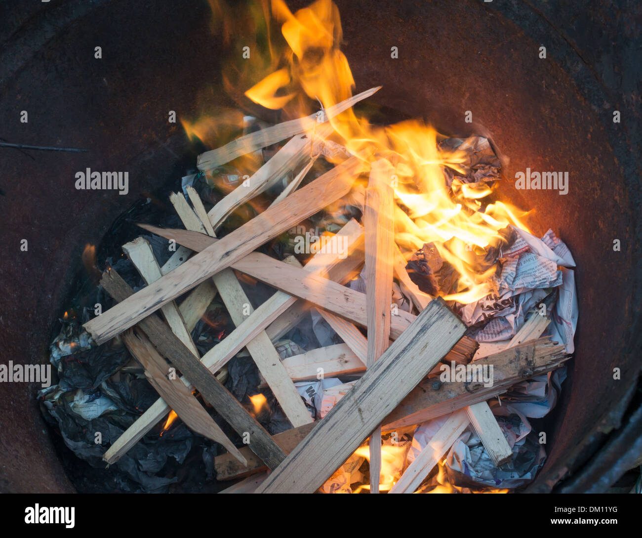 Ein Holzfeuer in einem alten Ölfass als einem Kohlenbecken angezündet Stockfoto