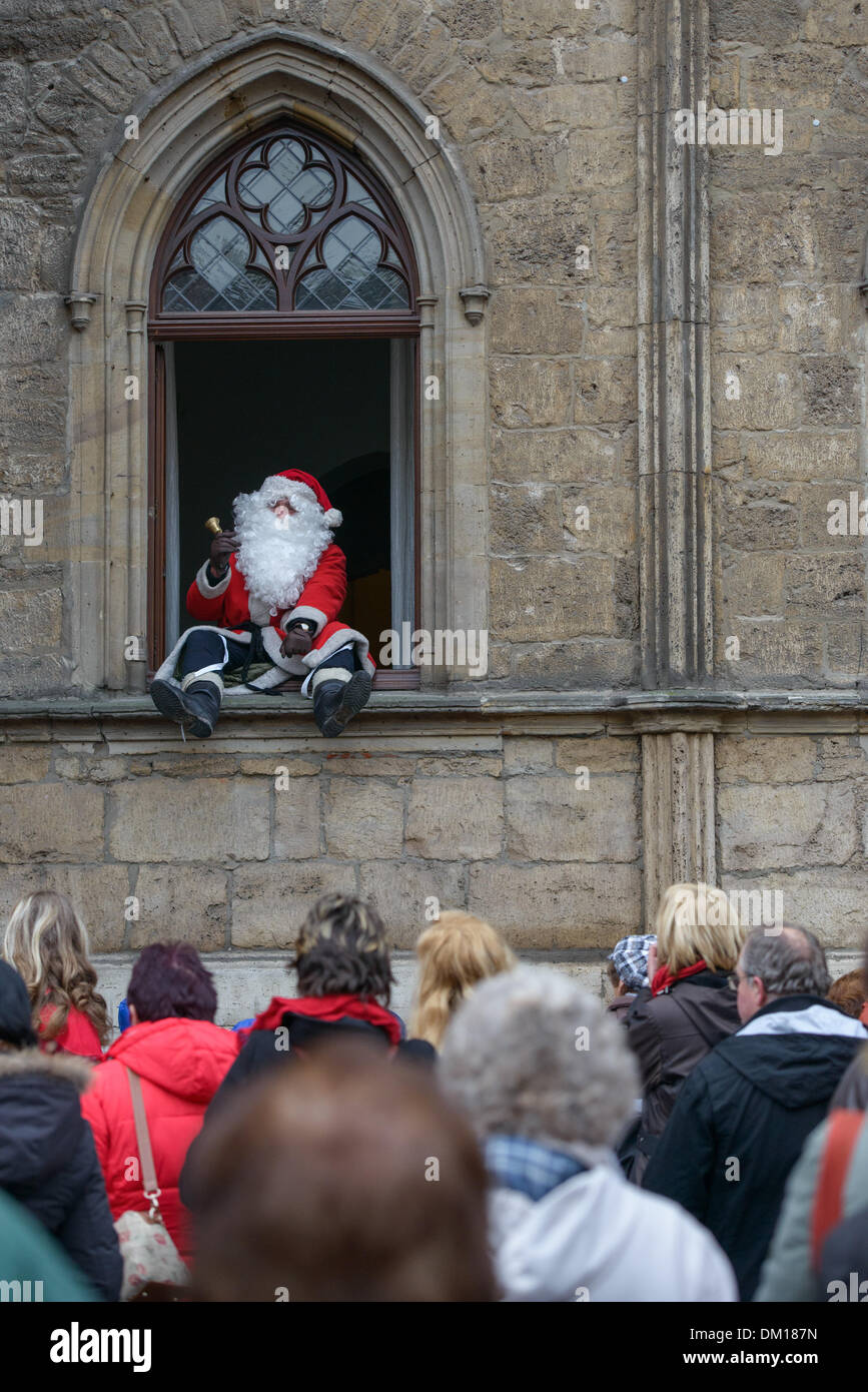 Weimar, Deutschland. 10. Dezember 2013. Ein Mann in ein Weihnachtsmann-Kostüm spricht von einem Fenster in das Rathaus in Weimar, Deutschland, 10. Dezember 2013. Jedes Jahr werden die Fenster des Rathauses in einen riesigen Adventskalender verwandelt. Foto: Candy Welz/ZB/Dpa/Alamy Live News Stockfoto