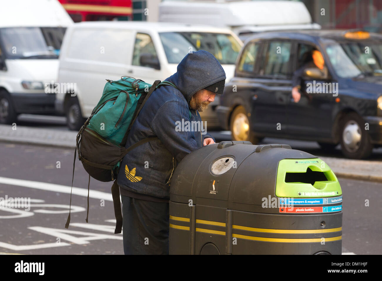Obdachlosen Mann Überprüfung Mülltonnen an einer befahrenen Straße London, Vereinigtes Königreich Stockfoto