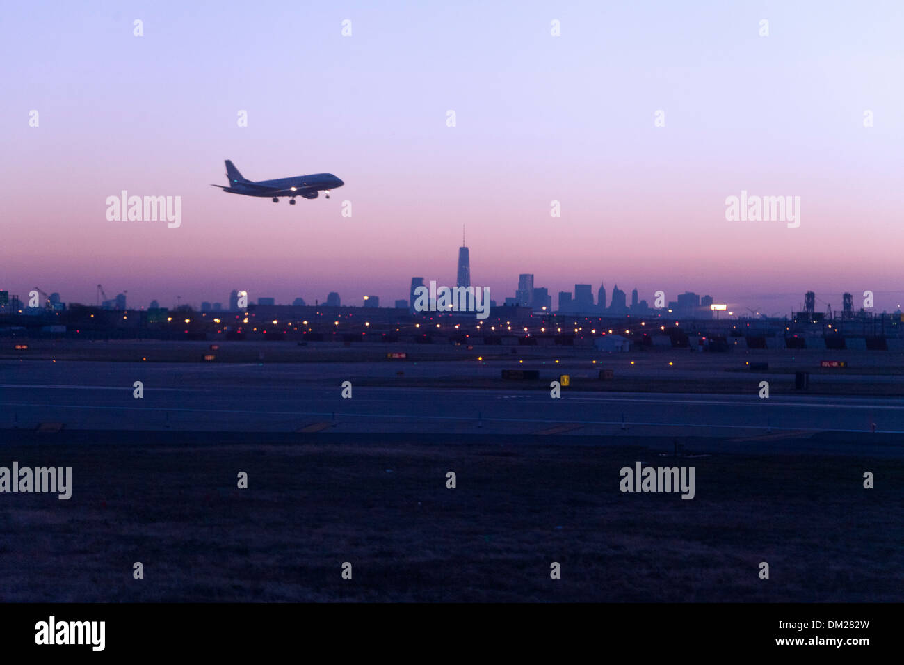 Flugzeug landet auf dem Flughafen Newark, bei Sonnenaufgang, New York City im Hintergrund Stockfoto