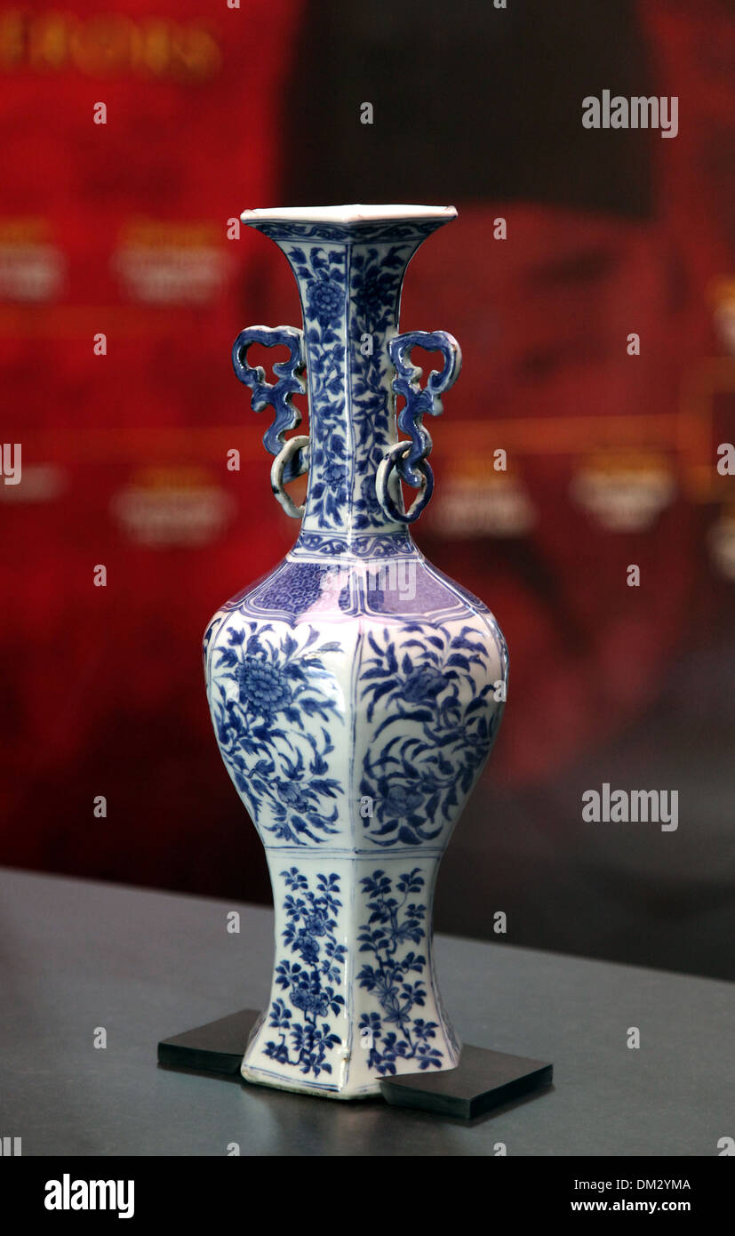Eine chinesische blau-weiße Porzellanvase aus dem 12. Jahrhundert, verziert mit komplizierten Blumenmustern, präsentiert auf einem dunklen Stand. Stockfoto