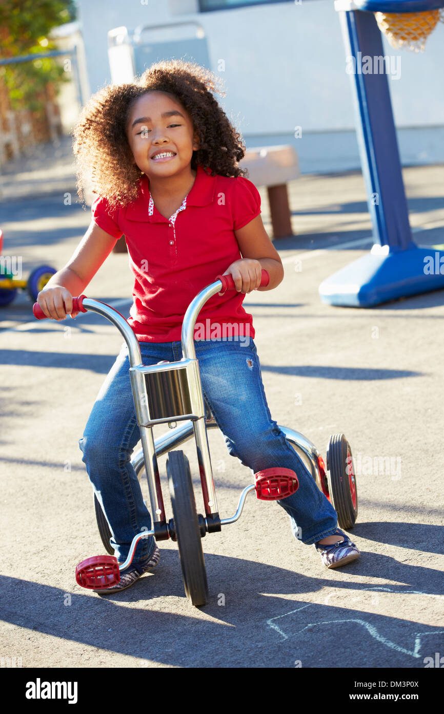 Kind-reiten-Dreirad auf Spielplatz Stockfoto