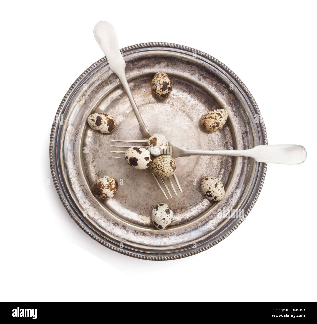 Uhr aus von Wachteleiern auf Silberplatte mit Gabeln, isoliert auf weißem Hintergrund Stockfoto