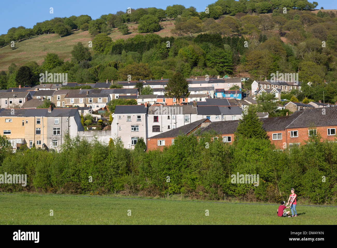 Zwei Personen auf dem Spielfeld vor Häusern, sechs Glocken, Wales, UK Stockfoto