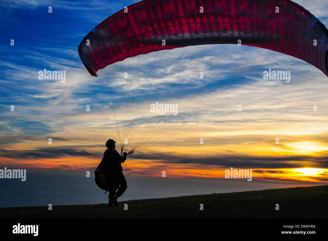 Beachy Head, Sussex, UK. 11. Dezember 2013. Erstaunliche Szenen in den Sonnenuntergang als Parawing Piloten suchen Aufzug in die Brise vom Meer auf den Hügeln oberhalb der Klippe. Vincent Talleu bläst seine Parawing in Vorbereitung für den Flug... Bildnachweis: David Burr/Alamy Live-Nachrichten Stockfoto