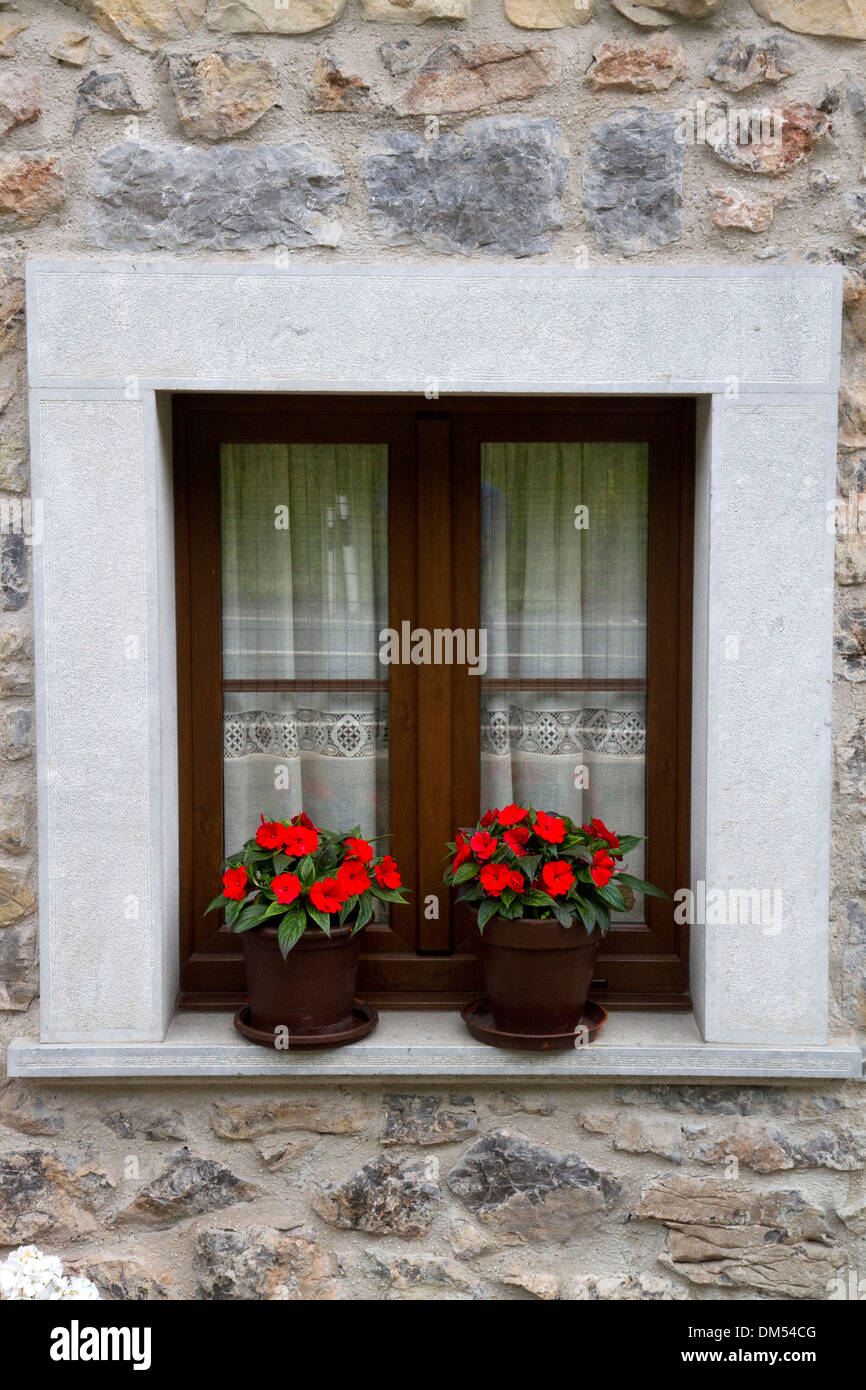 Wohnungsbau mit Blumen in Windows in der Gemeinde von Cangas de Onis in Asturien, Spanien. Stockfoto