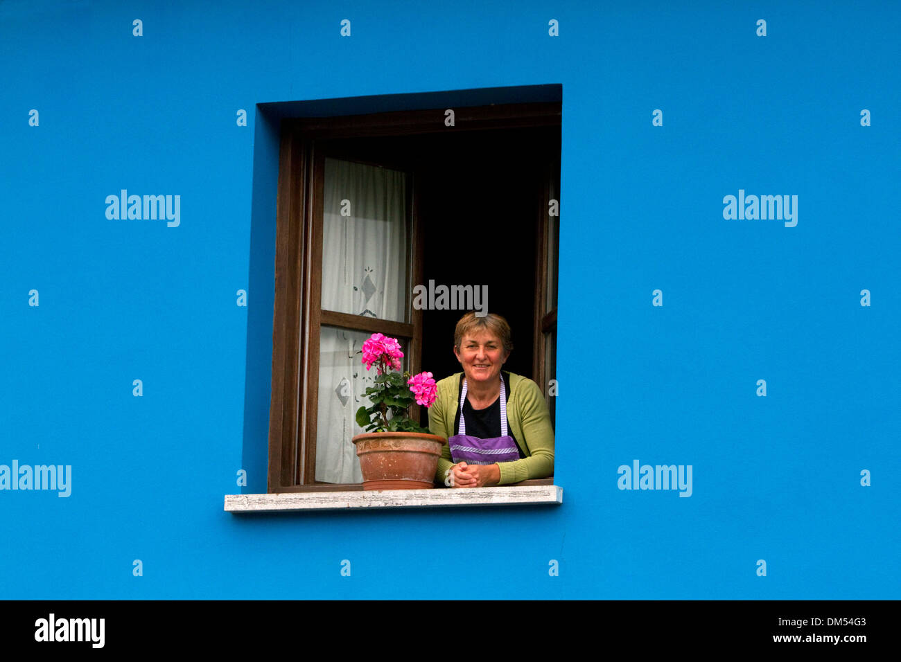 Spanierin im Fenster ihres Hauses in der Gemeinde von Cangas de Onis in Asturien, Spanien. HERR Stockfoto