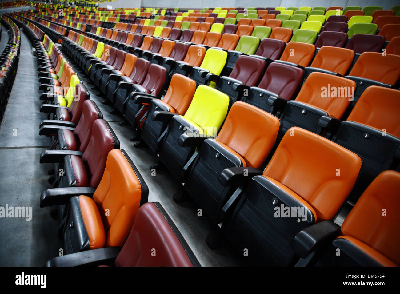 Leere Sitzreihen in verschiedenen Farben in einem Stadion Stockfoto