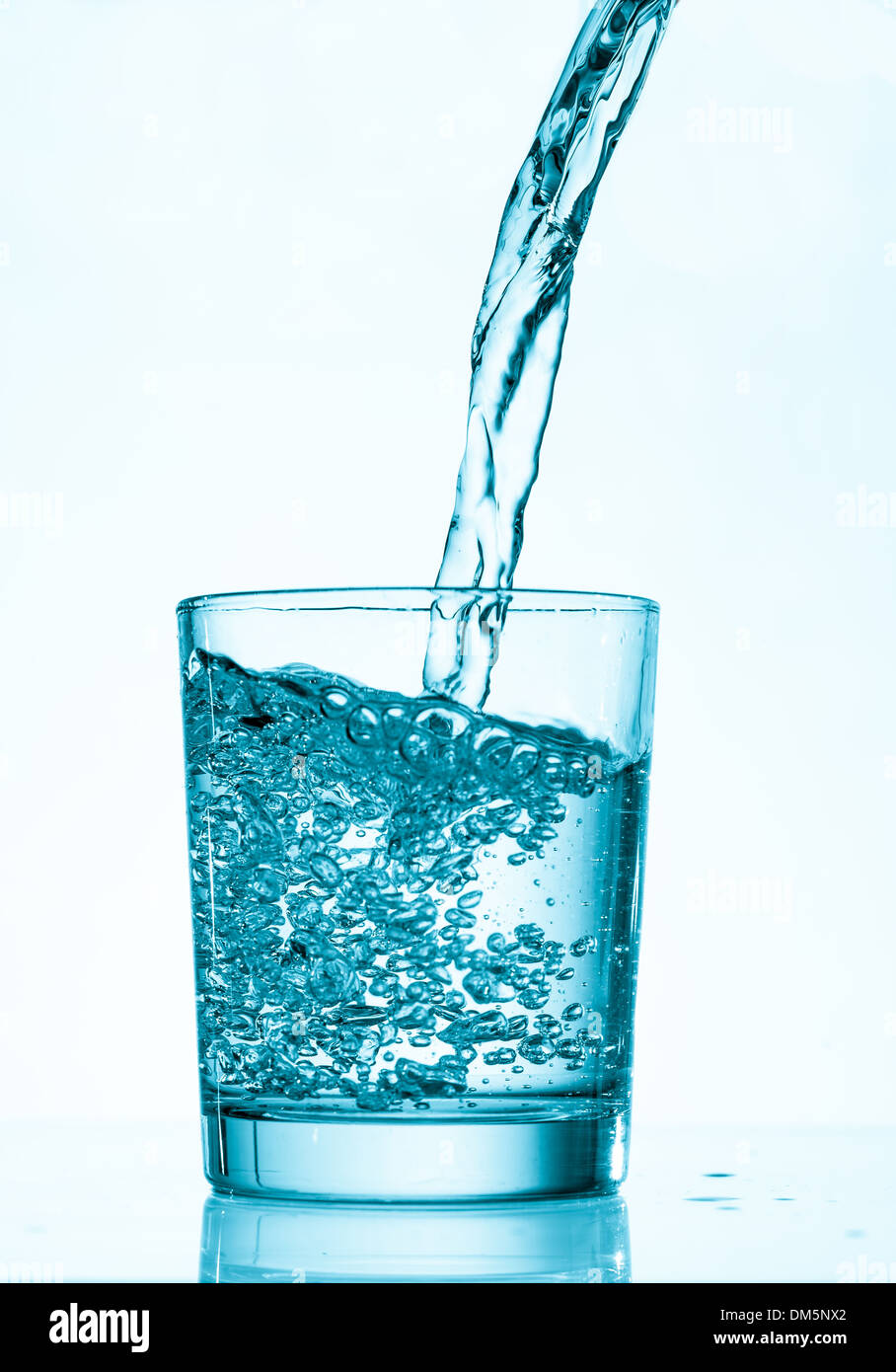 Wasser aus einem Krug in ein Glas gießen Stockfoto