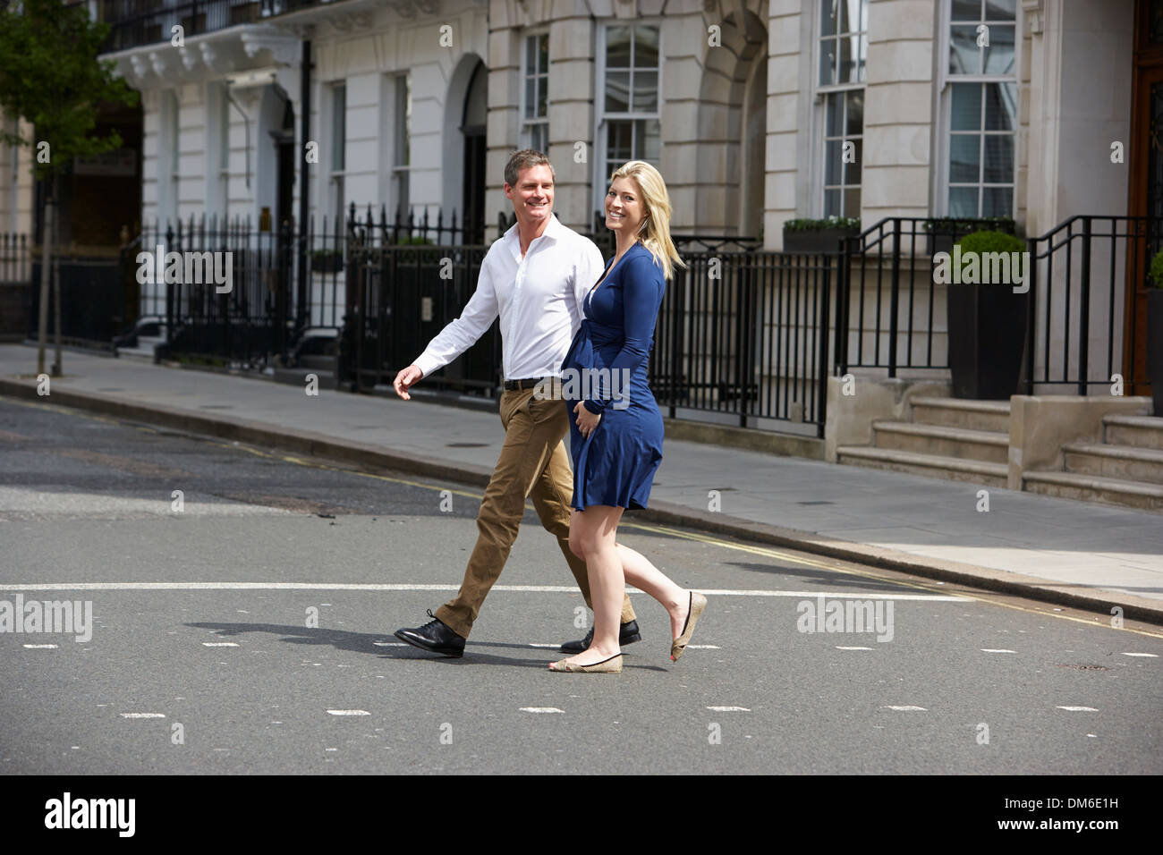 Paar mit schwangere Frau Crossing City Road Stockfoto