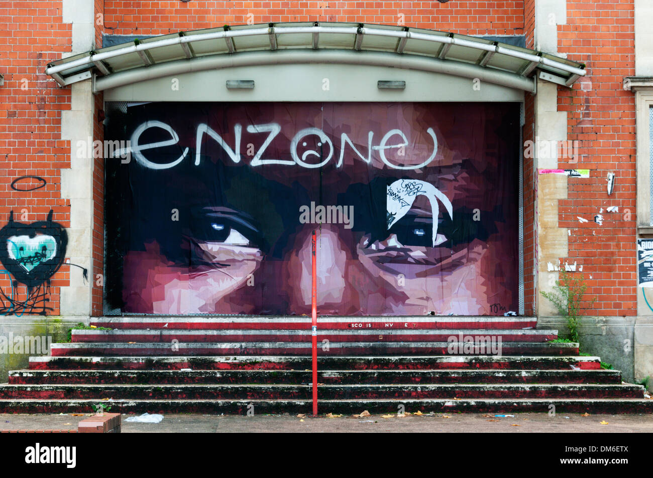 Graffiti von Tom im Bereich Stokes Croft von Bristol auf dem ehemaligen Kino und Narren-Comedy-Club. Stockfoto