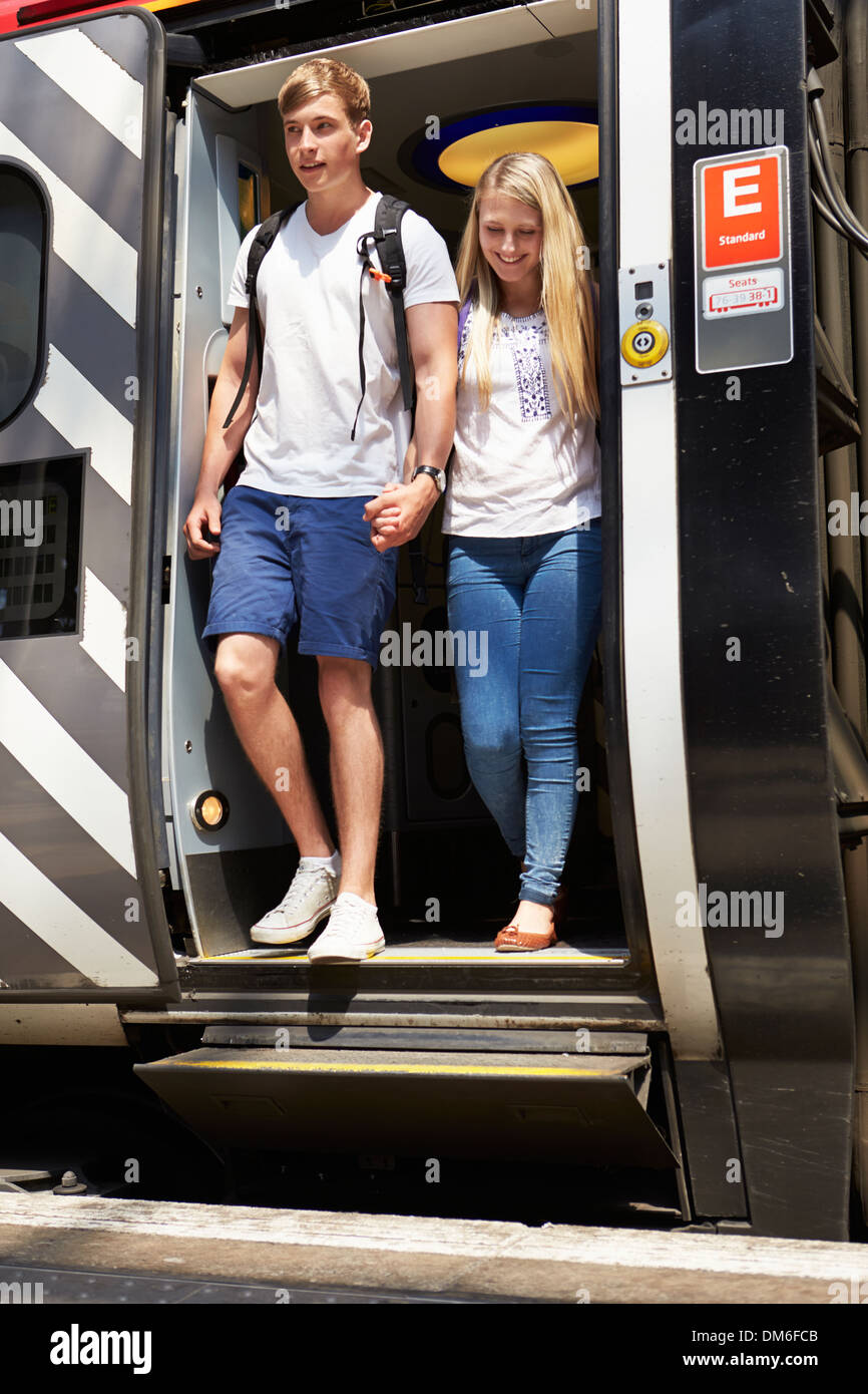 Junges Paar Aussteigen aus dem Zug am Bahnsteig Stockfoto