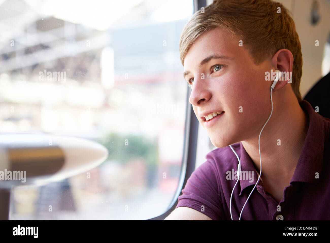 Junger Mann anhören von Musik auf Zugfahrt Stockfoto
