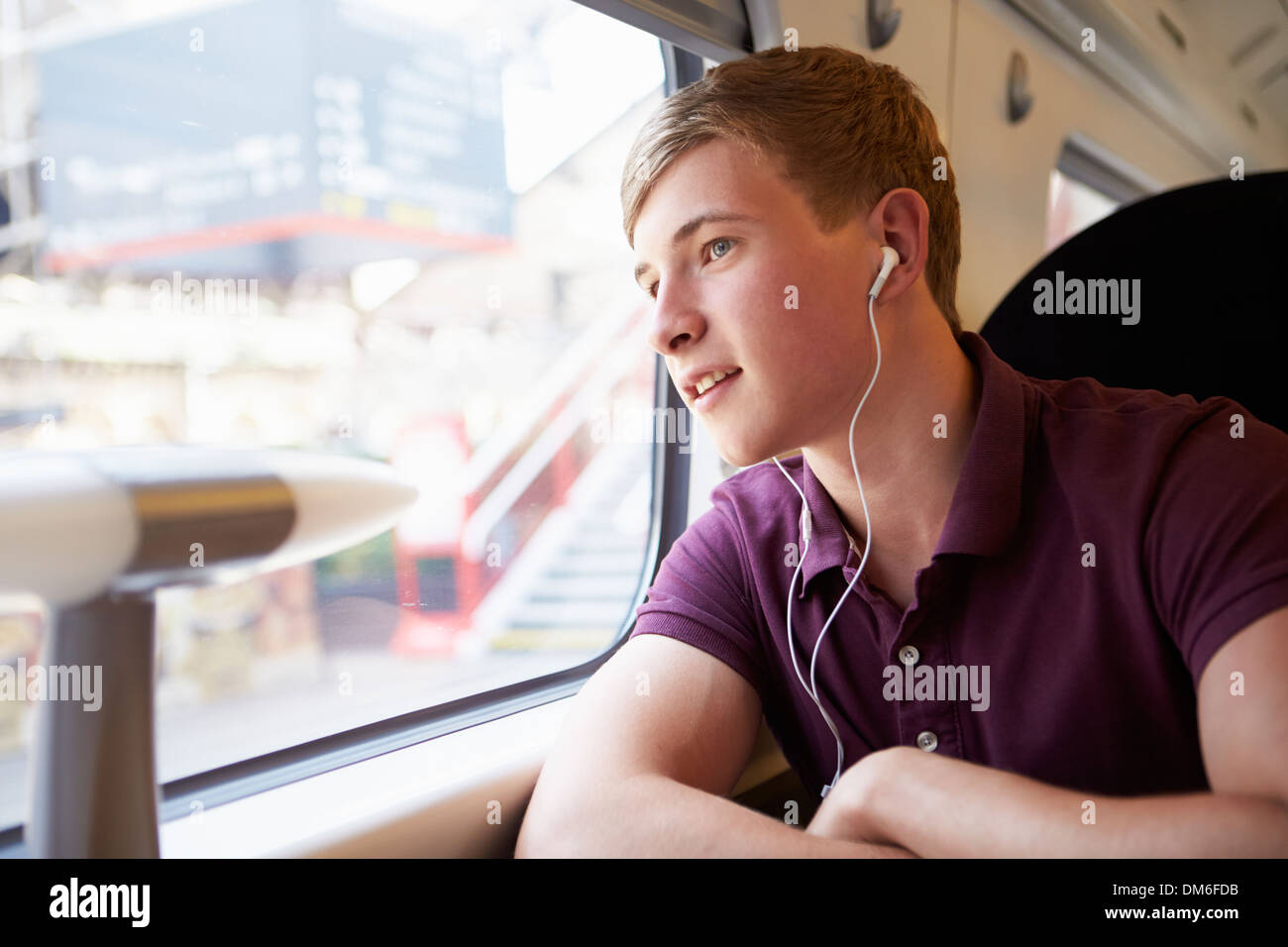 Junger Mann anhören von Musik auf Zugfahrt Stockfoto
